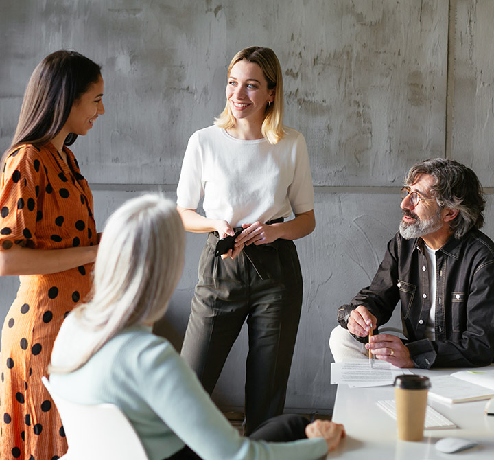 Group of office workers discussing by a table.