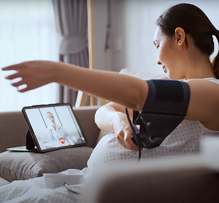 Patient using a blood pressure medical tool while using telehealth conferencing with a doctor