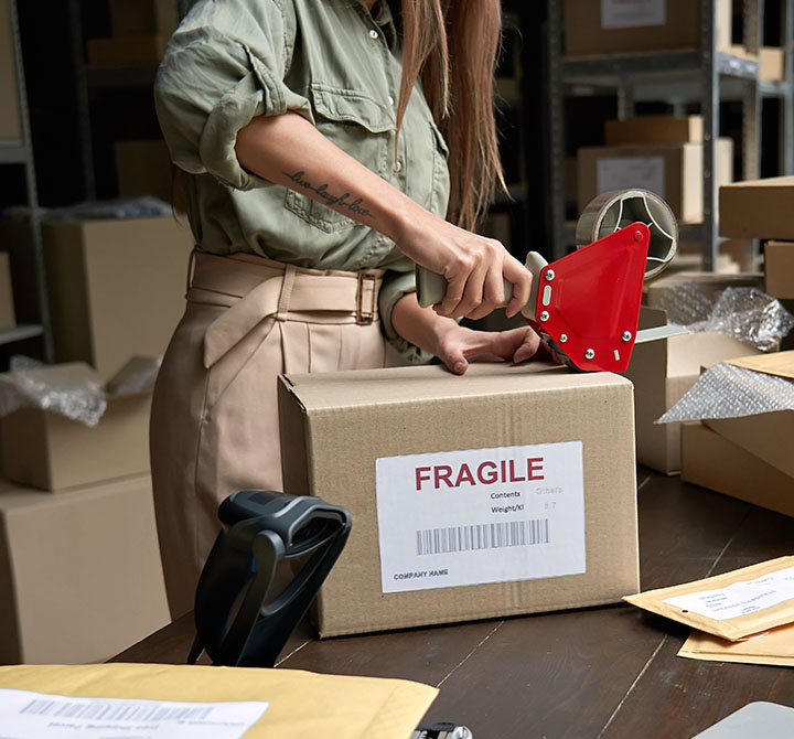 Female taping up a box for shipping