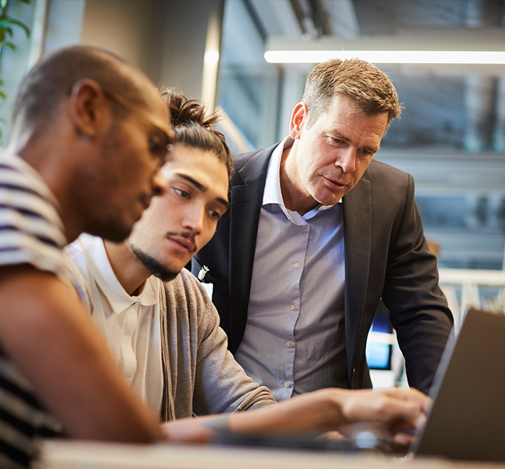Group of people huddled around a computer working