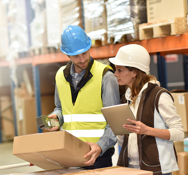 Warehouse workers using a tablet in a warehouse