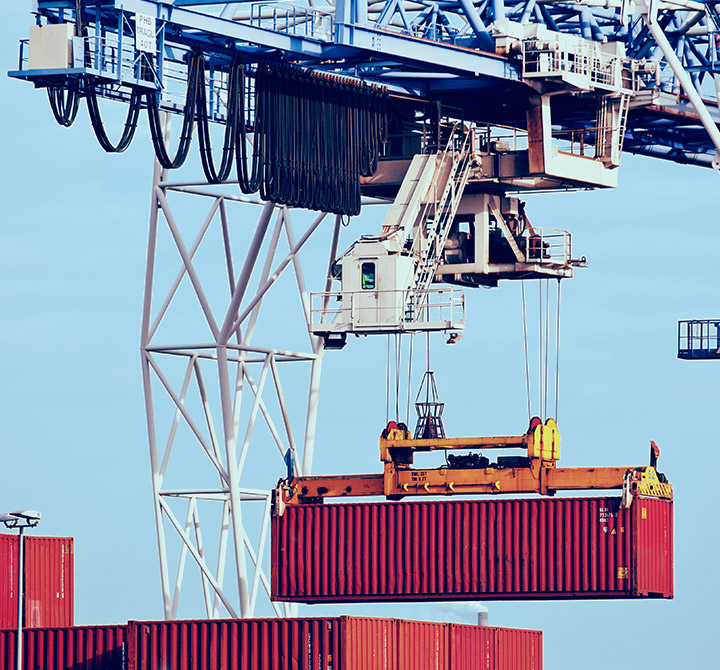 Crane carrying a large freight container.