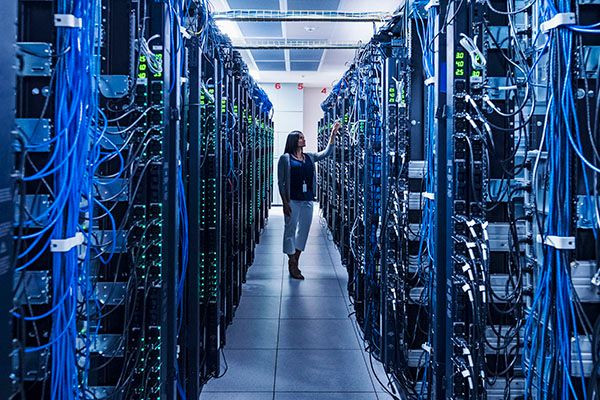 Woman standing in aisle of server room